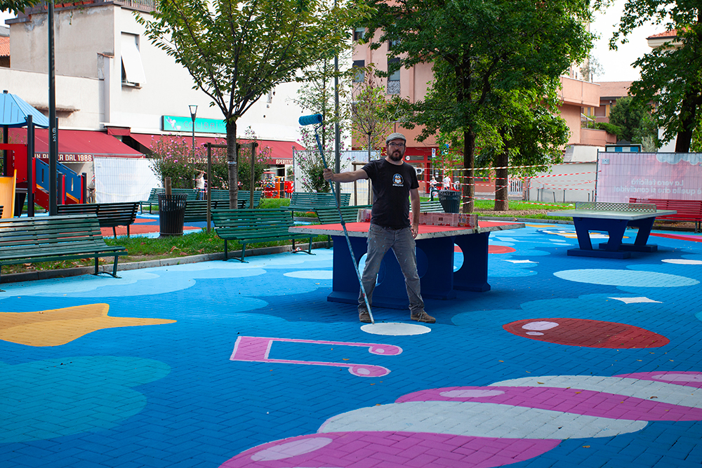 PAO mentre dipinge il floor painting colorato di Piazza Belloveso a Milano per il progetto HARIBO Happyland, street art urbana tra gioco e fantasia PAO mentre dipinge il floor painting colorato di Piazza Belloveso a Milano per il progetto HARIBO Happyland, street art urbana tra gioco e fantasia
